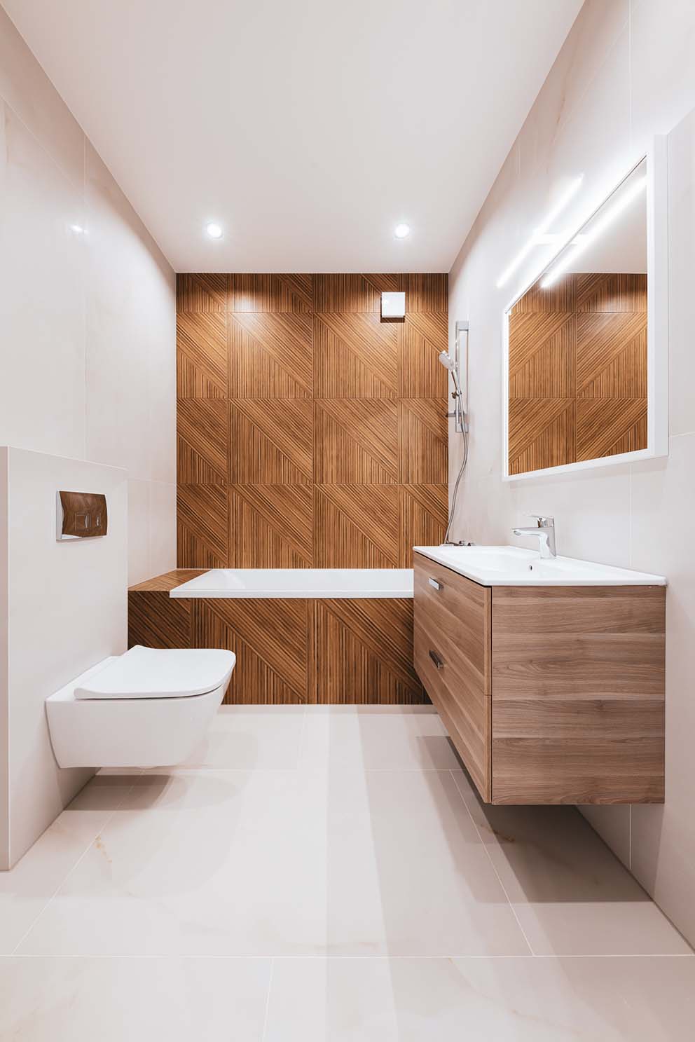 Weiß verfliestes Bad mit Keramiktoilette, Badewanne mit Holzvertäfelung und holzvertäfelter Badezimmerkonsole.